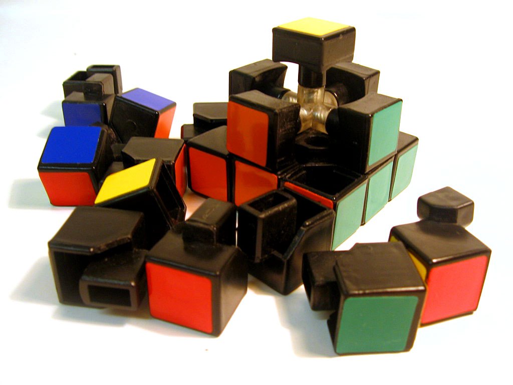 Piezas de un cubo de Rubik desarmado, con aristas y esquinas sueltas y parte del núcleo a la vista