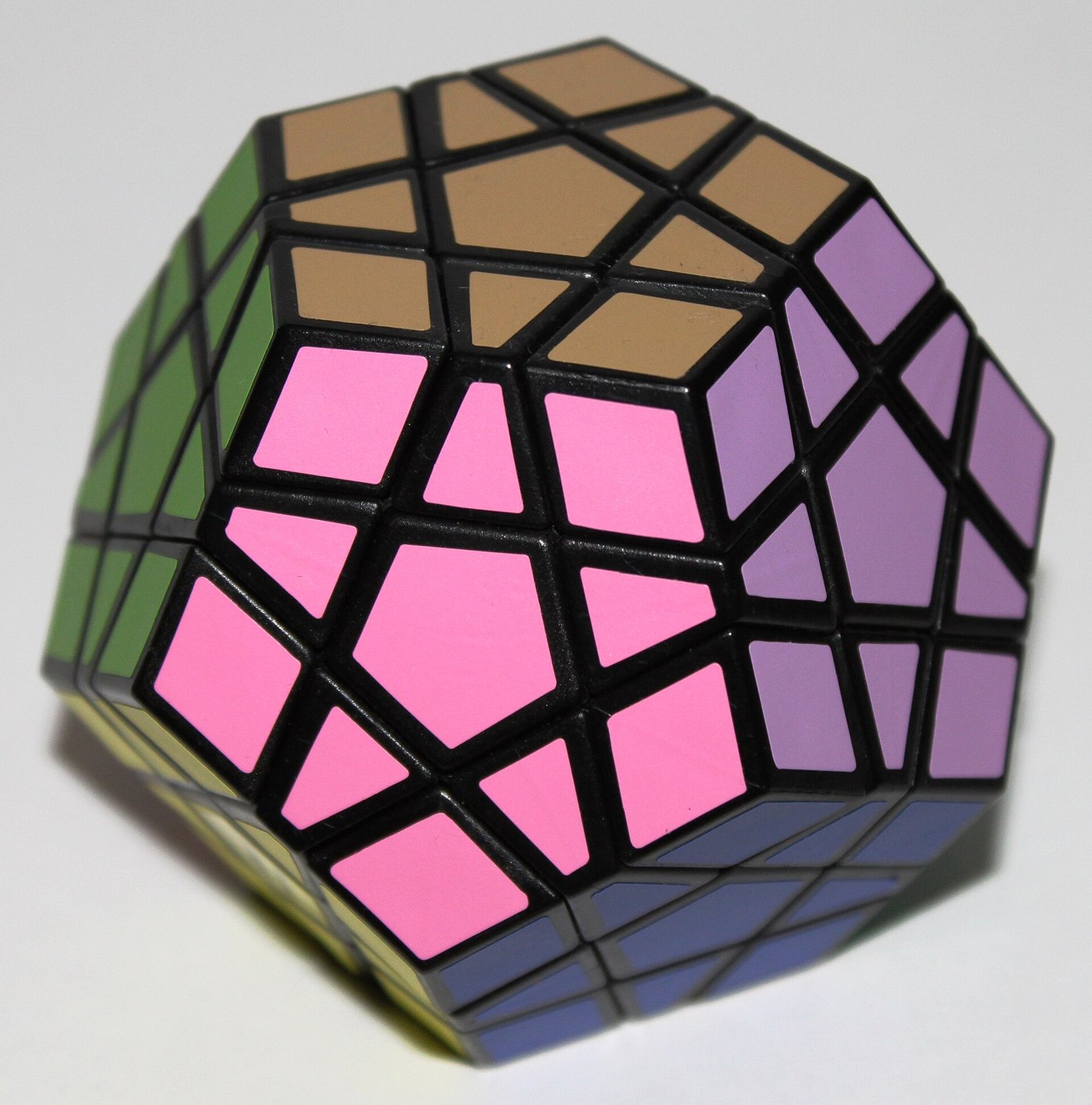 Megaminx armado a medias, con piezas rosas, violetas, marrones y verdes sobre fondo claro.
